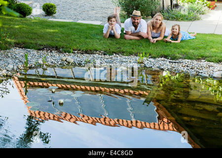 Family with two children takes a break by the pond, Munich, Bavaria, Germany Stock Photo