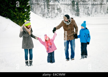 Family with two children in snow-covered landscape having fun, Bavaria, Germany Stock Photo