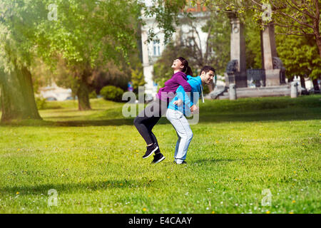 Man holding girlfriend on back in park, Osijek, Croatia Stock Photo