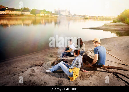 Group of friends relaxing by campfire on the riverbank, Osijek, Croatia Stock Photo