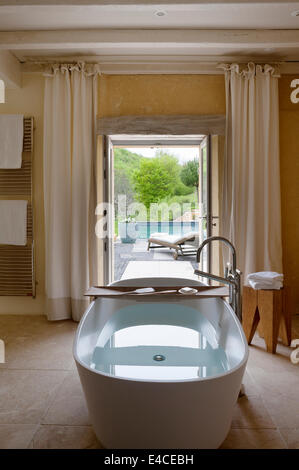 A Deep VAS 910 bath from Agape in bathroom with with garden entance and views Stock Photo