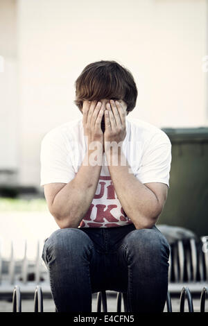 Young BMX biker covering eyes Stock Photo