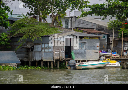 Houses & boats along a river in the Mekong Delta, Vietnam Stock Photo