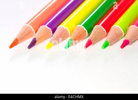 Row of color pencils on white paper Stock Photo