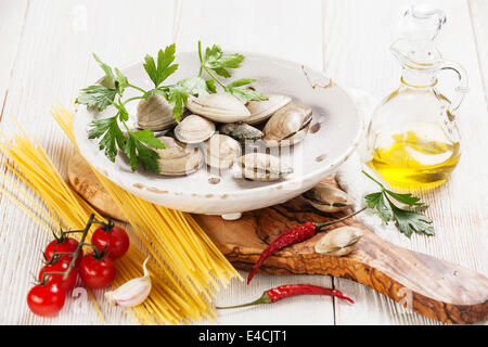 Ingredients for cooking spaghetti vongole Shells vongole, raw spaghetti, parsley leaves, cherry tomatoes Stock Photo