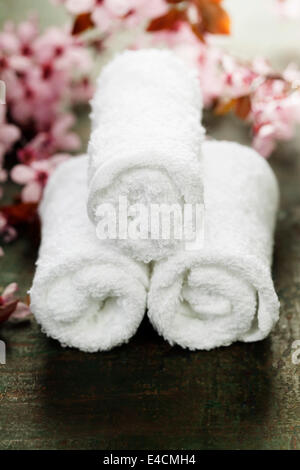 towels and spring cherry blossoms on wooden table Stock Photo