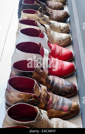 Handmade boots of differing materials in a row Stock Photo