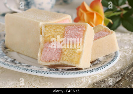 Battenberg Cake or Battenberg Square a sponge cake with pink a yellow checks covered in marzipan Stock Photo