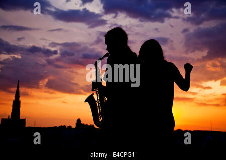 Young man playing the saxophone at sunset, Osijek, Croatia Stock Photo