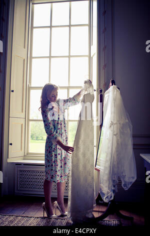 Wedding preparations, Bride examining wedding dress, Dorset, England Stock Photo