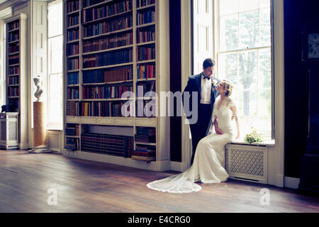 Wedding preparations, Bride and bridegroom in library, Dorset, England Stock Photo