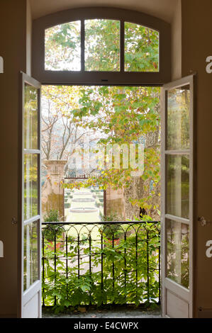 View through open windows out to garden with topiary and fountains Stock Photo