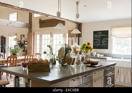 Concrete worktops in a kitchen with French pendant lights and glass storage jars Stock Photo