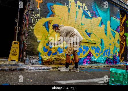 Graffiti artist at work in Melbourne laneway Stock Photo