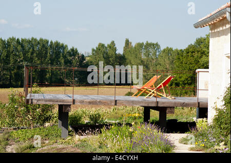 Pair of deck chairs on low oak deck with iron balustrade and rural views Stock Photo
