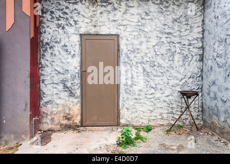 Rough Concrete Wall with Wood Door and Fire Torch Stand. Stock Photo