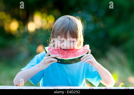 Boy Eating Watermelon Outdoors Stock Photo