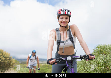 Fit couple cycling on mountain trail Stock Photo