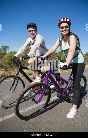 Active happy couple going for a bike ride in the countryside Stock Photo