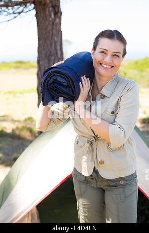 Outdoorsy woman smiling at camera outside her tent Stock Photo