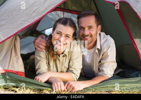 Outdoorsy couple smiling at camera from inside their tent Stock Photo