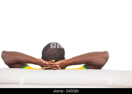 Man sitting on sofa with hands behind head Stock Photo