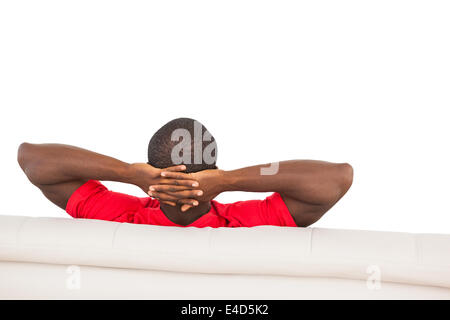 Man in red jersey sitting on couch Stock Photo