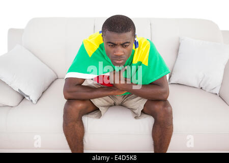 Upset brazilian football fan sitting on couch Stock Photo