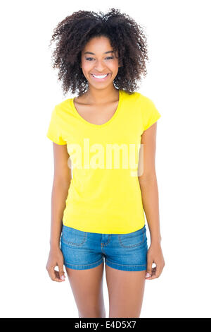 Pretty girl in yellow tshirt and denim hot pants smiling at camera Stock Photo
