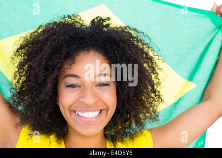 Pretty girl in yellow tshirt holding brazilian flag smiling at camera Stock Photo