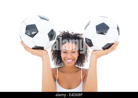Pretty girl holding footballs and smiling at camera Stock Photo