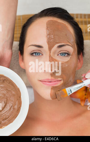 Peaceful brunette getting a mud facial applied Stock Photo