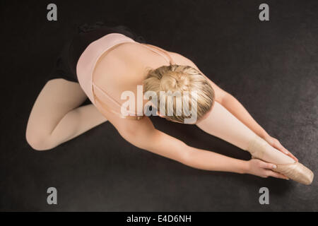 Ballerina sitting and bending forward Stock Photo