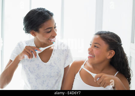 Pretty mother brushing her teeth with her daughter Stock Photo