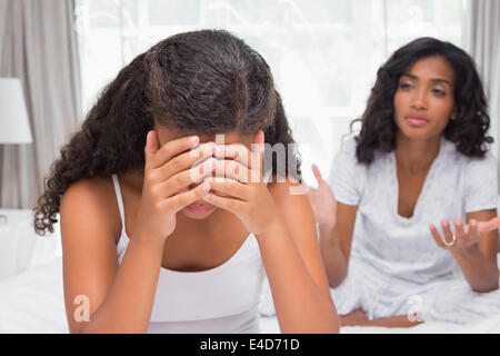 Mother and daughter having an argument on bed Stock Photo