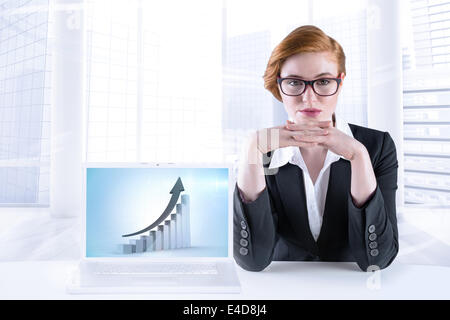 Composite image of redhead businesswoman sitting at desk Stock Photo