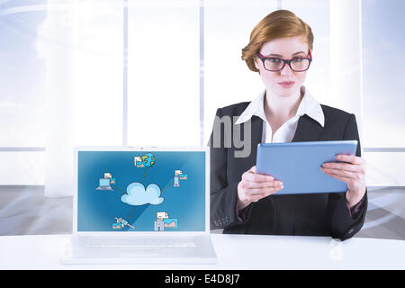 Composite image of redhead businesswoman using her tablet pc Stock Photo