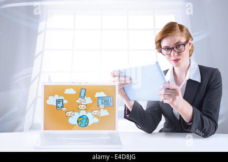 Composite image of redhead businesswoman using her tablet pc Stock Photo