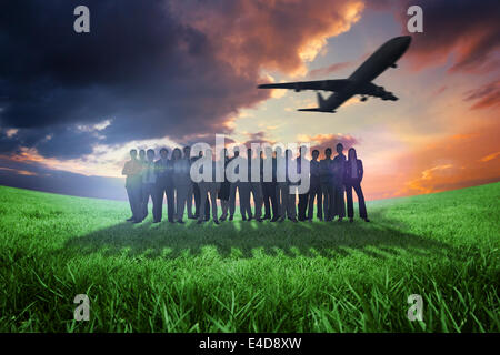 Composite image of business people standing up with airplane Stock Photo