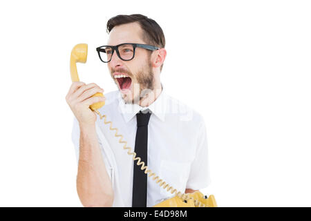 Geeky businessman shouting at telephone Stock Photo