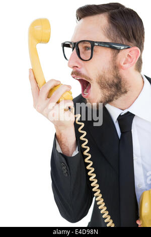 Geeky businessman shouting at telephone Stock Photo
