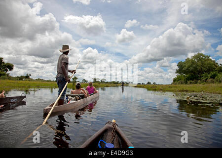 tourists  on a traditional mokoro boat in the Okavango Delta, Botswana, Africa Stock Photo