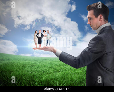 Composite image of businessman holding business team Stock Photo