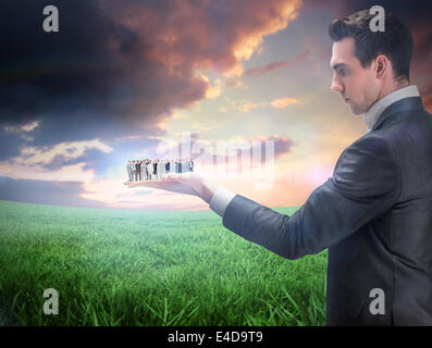Composite image of business team holding up arrow Stock Photo - Alamy