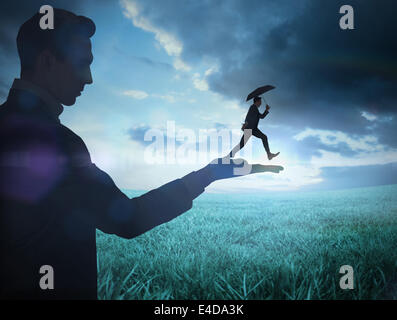 Composite image of businessman holding business man jumping Stock Photo