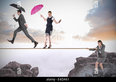 Young businesswoman pulling a tightrope for business people Stock Photo