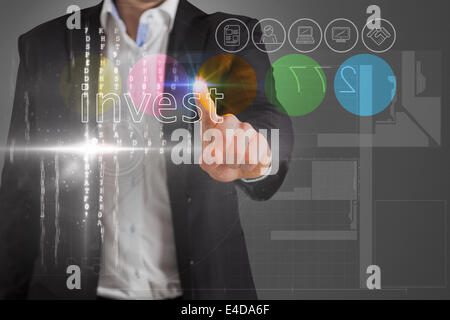 Businessman touching the word invest on interface Stock Photo