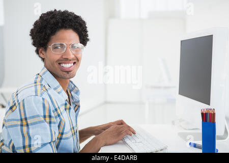 Young designer working at his desk smiling at camera Stock Photo
