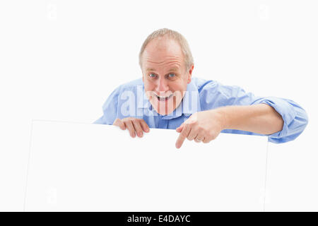 Mature man smiling at camera and pointing Stock Photo