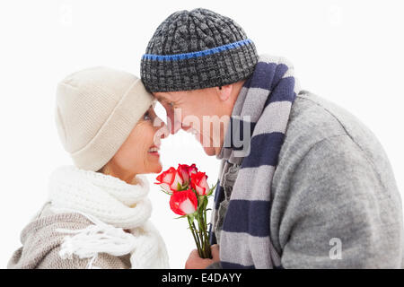 Happy mature couple in winter clothes with roses Stock Photo